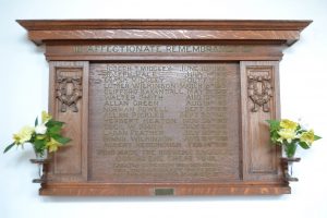 An oak board with carved tope and sides and a listed of names on the men of the church who died in the first world war