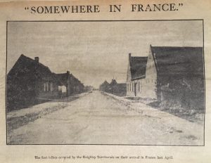 An old newspaper photo showing small houses either side of a road which stretches into the distance.