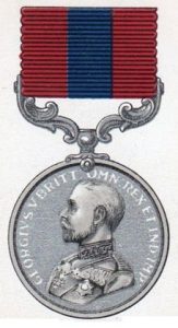 The Distinguished Conduct medal. A round sliver medallion with the head of King George 5th. The ribbon above is a dark blue vertical stripe with a dark red vertial stripe on either side.