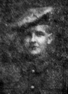 A black and white photo of the head and shoulders of a man in British Army uniform. Newspaper photo, so poor quality.