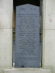 A war memorial panel shaped like a gravestone. It is grey-green granite and has 22 names inscribed.