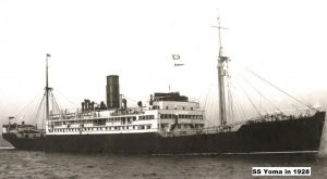 A black and white photograph of a merchant ship, Steamship Yoma. The ship has a dark coloured hull and white superstructure. There is one funnel amidships and a large mast at front and a similar one aft. She is at sea and thre are very few waves visible.