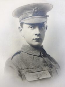 A slightly retouched head and shoulders portrait photo of a soldier in Army uniform facing the camera.